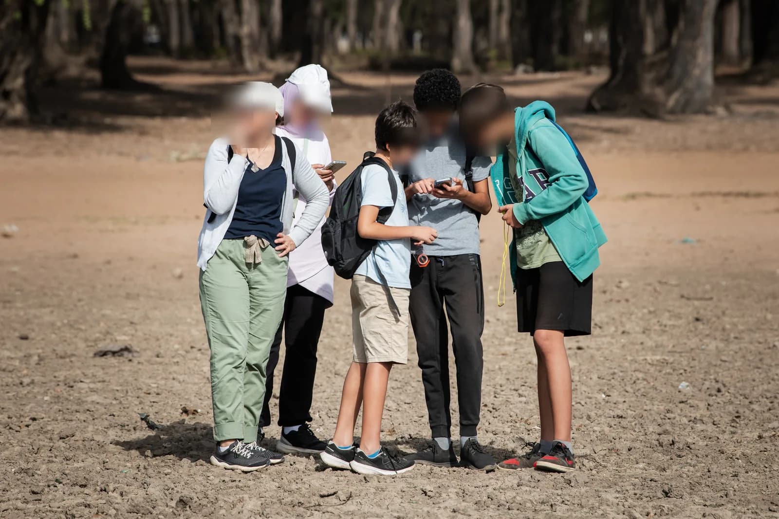 Maamora Challenge participants gathered around their phones during the game.