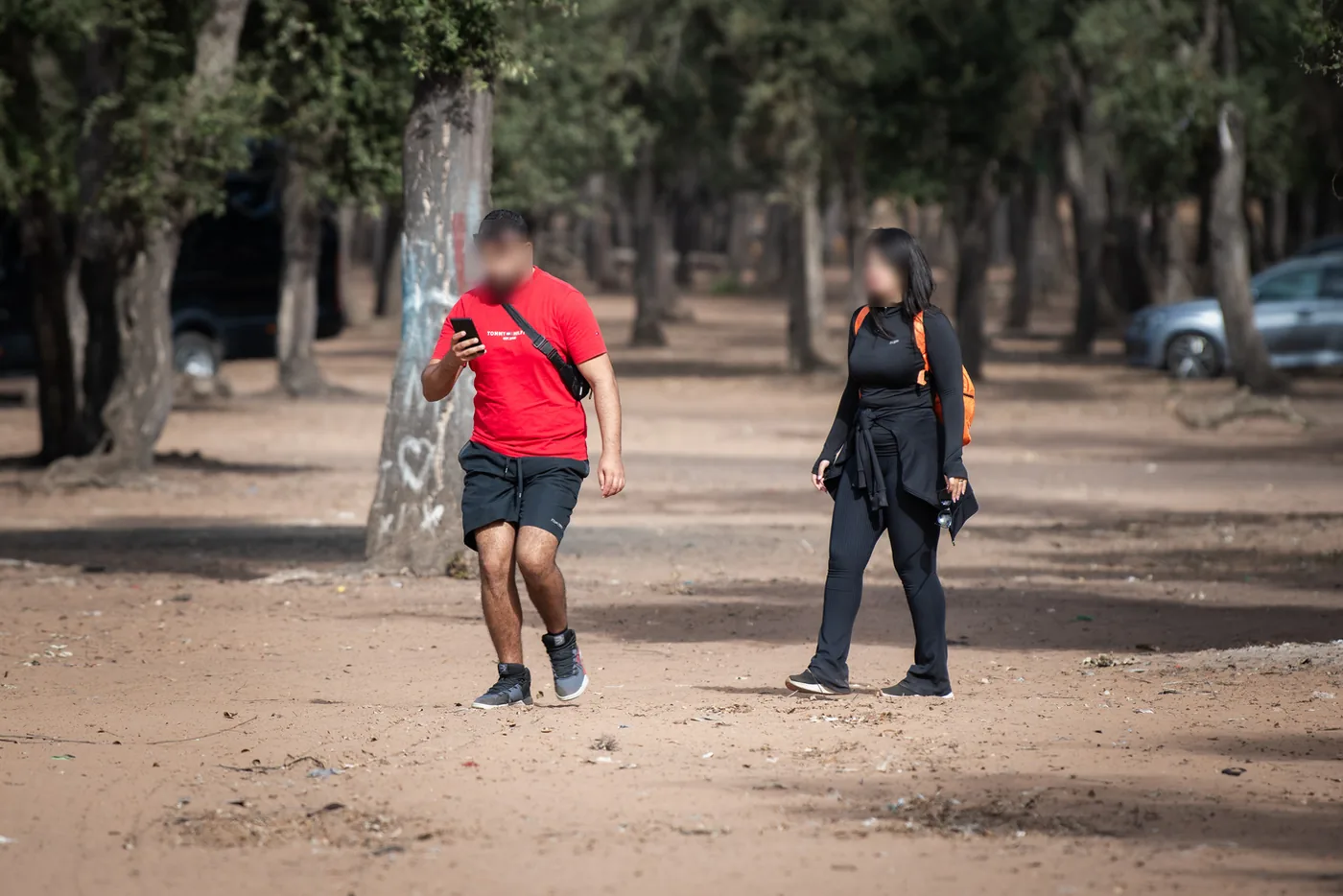 Two Maamora Challenge participants crossing the forest, phone in hand.